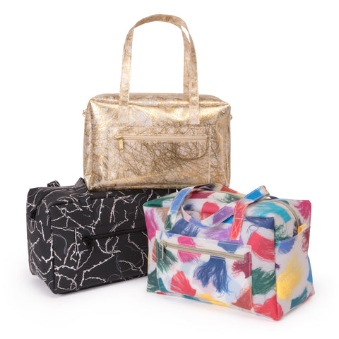 Three translucent small duffle bags. Each detailing a different scrap fabric including silk tassel, gold fringe, and yarn