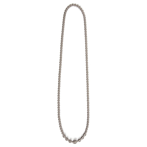 A long necklace that can be wrapped twice around the neck. Made from stainless steel beads, which are bigger at the center of the piece.  