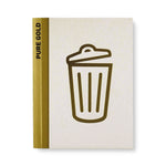 Chipboard cover with gold foil icon of a trash can and gold foil spine with words "Pure gold" in black sans serif letters