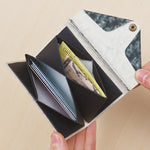 Interior view of the Farmer's Felt Double Case Nest wallet. Credit cards, and cash have been placed inside the wallet to show its various storage spaces.