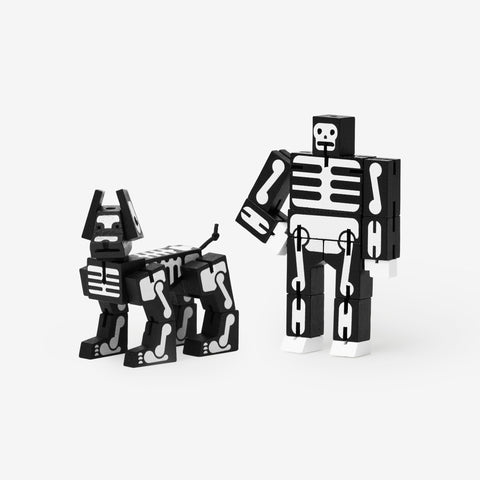 Articulated wooden robot and dog toys, painted black with white skeleton bones.