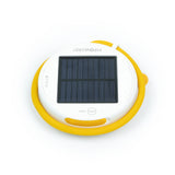 Solar-panel side up, disk-shaped light with its flexible yellow arm wrapped around it.