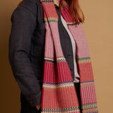 Person wearing a colorful patterned scarf with a plain background