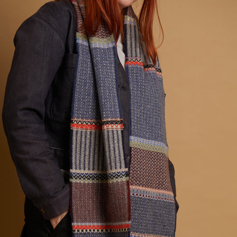 Person wearing a patterned scarf with a plain background