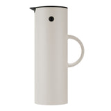 Cylindrical, Soft Sand vacuum jug with a thin, semi-circle handle, a black lid with a beak-shaped pour spout, and a black button "eye."