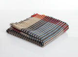 Stack of plaid blankets in various colors on a white background
