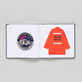 Interior book spread featuring an MTA patch on one page, and an orange Metro North jacket on the other.