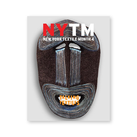 Gray magazine cover with a multi media and multi textural mask with magazine title in orange centered over the mouth opening and the magazine logo in red and white near the top