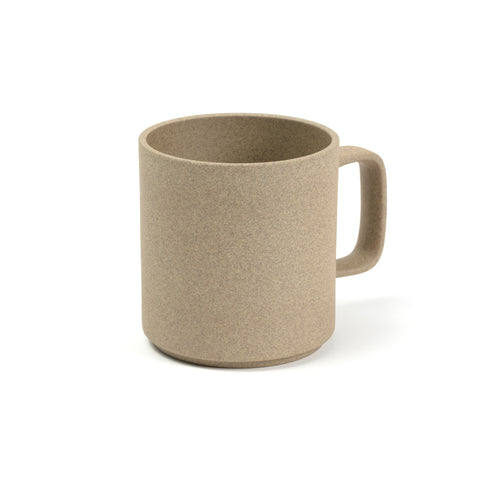 3/4 view of a mug on a white background. The color and texture is like pressed sand. Mug has straight sides and a rectangular handle with rounded corners.