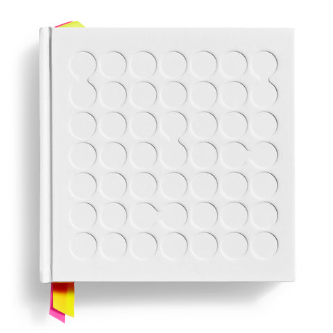White square book cover with debossed circles, some connected and multicolored ribbons peeking from top and bottom of spine