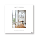White square book cover with central photograph of a museum gallery with wood floors white walls and ceiling with skylights. Title in gray letters above.