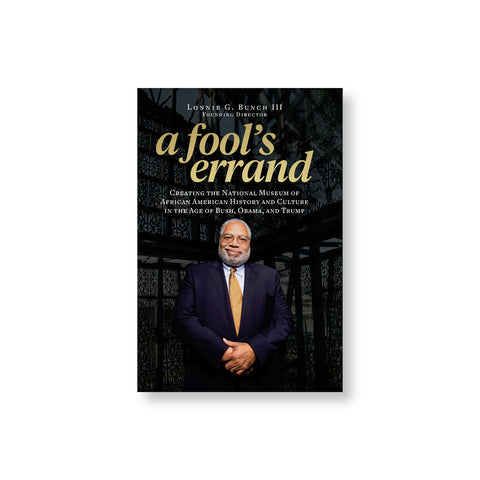 Book cover featuring portrait photo of a white bearded medium dark skin figure in a blue suit with golden yellow tie. Title in lower case golden letters above