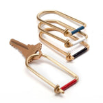 Four brass U-shaped key ring with enamel detail in red, blue, white and black.