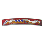 A brooch shaped like long and narrow rectangular with architectural motif inscribed in the middle decorated with orange, white and blue details on a red background. 