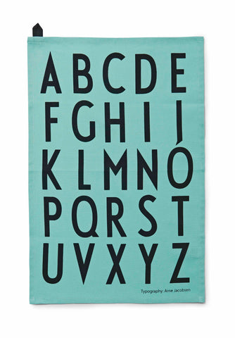 A light turquoise cotton rectangle printed with a bold black alphabet. 
