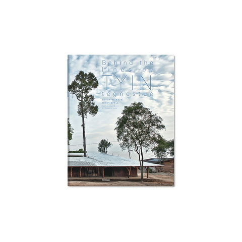Book cover with photograph of a stout building surrounded and punctured by tall trees in front of a cloudy blue sky. Title in thin blue font above