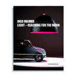 Book cover with photograph of a compact blue car under a giant black pendant light emitting magenta light in a dark space. Title in white sans serif letters near top