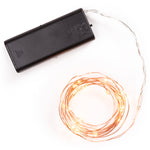 Spool of Copper String Lights in on position with black battery pack on white background.