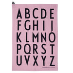 A light pink cotton rectangle printed with a bold black alphabet. 