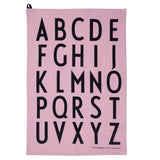 A light pink cotton rectangle printed with a bold black alphabet. 
