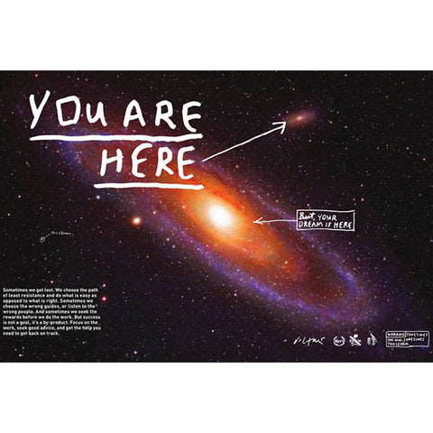 A poster featuring an image of the milky way. White text reads "You are Here" with an arrowing pointing to one area of the image. White text reading "But your dream is here" with an arrow pointing to a different spot.