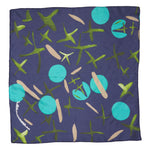 A navy blue silk scarf with green, light blue and beige geometric shapes painted across its center.