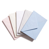 Four envelopes in different color variations laid out like a fan. Colors shown are light blue, light grey, white, cream, and pale pink.