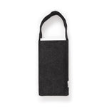 Side view of a dark gray felt Molo carrying bag for the Softseat Stool with identifying tag and shoulder strap, showing the white top of a slightly protruding folded Stool. 