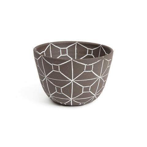 Small matte brown bowl that flares outward toward the top and has a rectangular etched out pattern in white.
