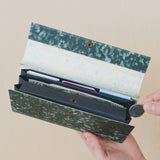 Interior view of the Farmer's Felt Triple Case Nest wallet. Several credits, cash, and coins have been placed inside the wallet to show its various storage spaces.
