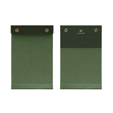 Front and back view of the palm-sized refillable notepad with snap closure in green with dark green border. The brand name and logo are embossed at center back in gold.