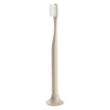 Tan toothbrush with matching color, round shaped stand.