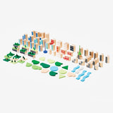 Against a white background, a photograph showing all the individual wooden pieces that make up the building set.  They are spread out evenly and arranged by category.