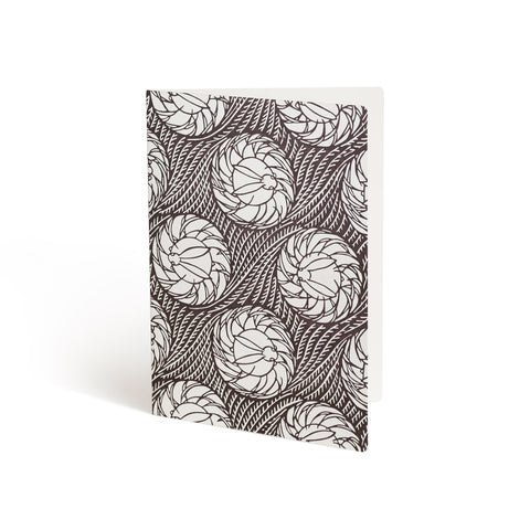 Printed in brown ink against a white background, the front of a card is covered in wavy rows of grass. Repeating Illustrations of rabbit medallions are layered over the grass and bleed off the edges.