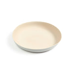 A medium-sized plate featuring a tan colored matte interior and white matte exterior. The rim of the plate is extended upward allowing for a deep dish styled plate good for gravy and other runny foods.
