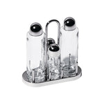 Viewed at an angle, from above: Minimal, post-modern, stainless-steel condiment caddy with four cylindrical empty glass vessels, two tall flanking two smaller, each with a rounded stainless steel cap.