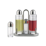 Viewed from straight on: a minimal, post-modern, stainless-steel condiment caddy holding three cylindrical glass vessels, one tall filled with a pale yellow olive oil, one tall filled with a red vinegar, flanking a smaller empty vessel. Another smaller empty vessel sits to the left of the caddy.