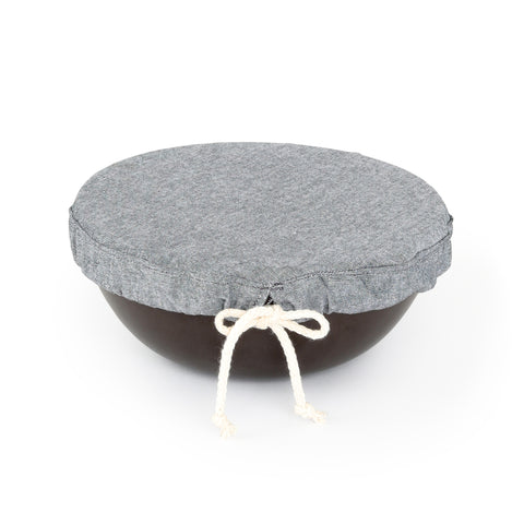 A round small sized grey cloth with tied draw string shown covering a small bowl.