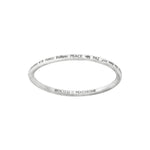 Silver-colored bangle with the word "PEACE" engraved in different languages around the outside.  "Article22 :: PEACE BOMB" is engraved on the inner side of the bracelet. 