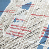 Detail of an unfolded tan and white map with red text and blue spot color for bodies of water.