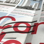Detail of the unfolded, reverse side of the map, zoomed in on cropped red text, with out-of-focus landmark photos and details behind.