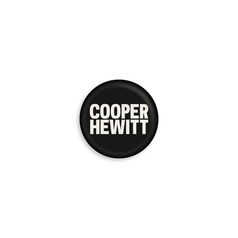Round hemp paper textured button with a black background and the Cooper Hewitt logo in white.