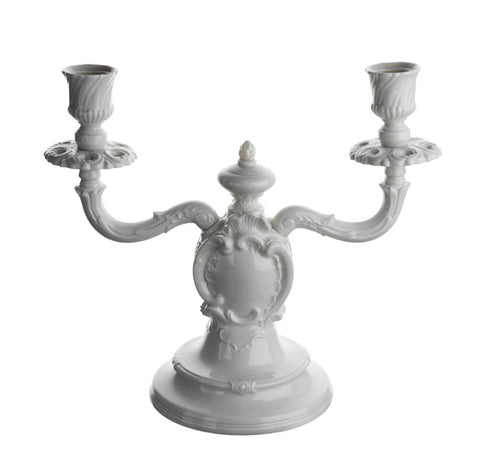 White, glazed porcelain candelabra, a Rococco model originally manufactured 1755-1800 with two Curvy upswept arms, a body with a swirling cartouche and an acorn finial.