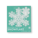 A lacy paper snowflake shows through clear packaging with a mint green cardboard backing.