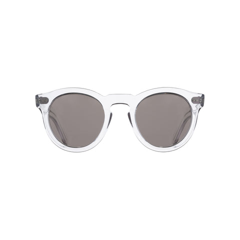 Round glasses with thick crystal frames and gray lenses. Upper hinges and keyhole bridge.