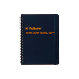 Classic rectangular notebook in dark blue with a black metal spiral on the left and navy elastic strap on the right. Manufacturers name, logo and 2 lines of neatly spaced text appear 1/3 from the top in orange sans serif letters.