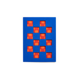 Royal blue greeting card with geometric cutouts: rows of squares with corner square cutouts, in red and orange.