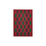 Maroon greeting card with geometric cutouts: rows of rectangles with triangle and diamond cuts in dark green and purple.
