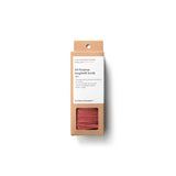 Rectangular, natural cardboard package with white label for the All Purpose Spaghetti Scrub, window-cut out reveals scrubber made up of many strips of coral-colored, textured material.