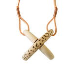 Two interlocking clay semicircles attached to the leather strap. One wooden element has a pattern of curved lines, another "leopard" spots. 